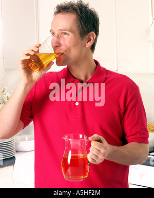 MAN IN KITCHEN DRINKING APPLE JUICE Stock Photo - Alamy