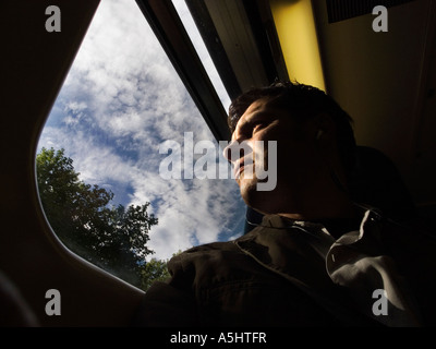 commuter looking through a train window alone Stock Photo