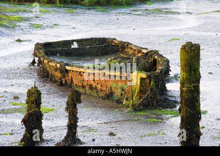 Rowing boat wreck at Bosham Harbour wallowing in mud Stock Photo