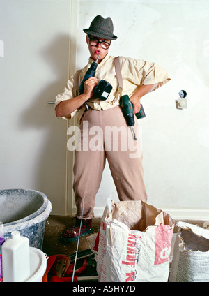 MR PR silly handyman do it yourselfer renovating a flat holding drilling machine like a weapon Stock Photo
