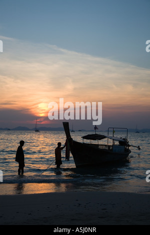 Long tail boats on Railay or Railey beach lagoon, Krabi Province Andaman Sea, Thailand, at sunset. Stock Photo