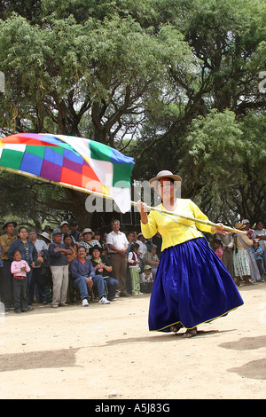 Young Traditional Woman dancing with a wiphala  (flag) in Tiataco, Cochabamba, Bolivia Stock Photo