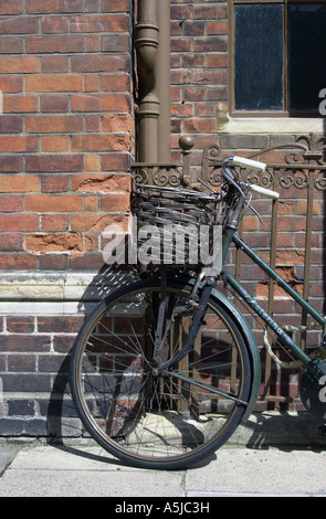 Traditional old cycle, bike, against iron railings and old brick wall Stock Photo