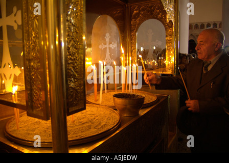 Man lighting a candle in a Greek Orthodox church Stock Photo