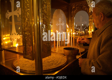 Man lighting a candle in a Greek Orthodox church Stock Photo