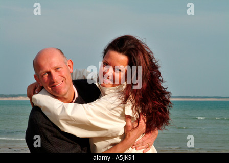MR lovers walking at seacoast in joyful embracement Stock Photo