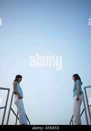 Two young women standing facing each other Stock Photo