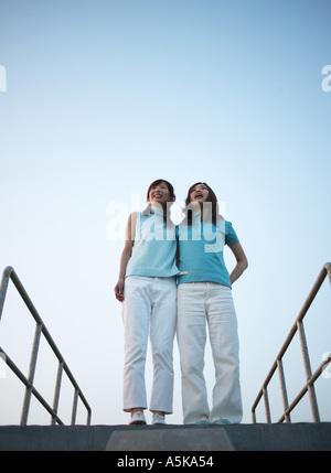 Two young women standing facing each other Stock Photo