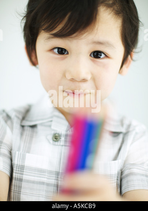 Young boy holding color pencils Stock Photo