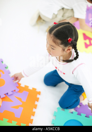 Young girl playing jigsaw puzzle Stock Photo