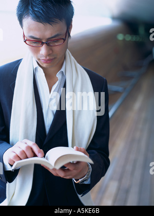 Asian Man reading on a bench Stock Photo