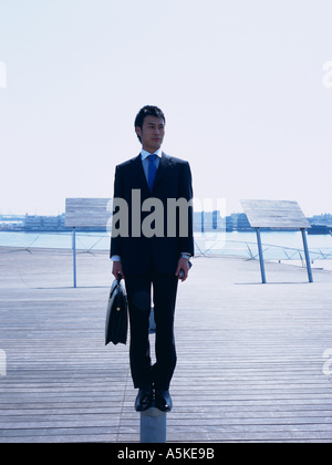 Asian man standing on a walkway Stock Photo
