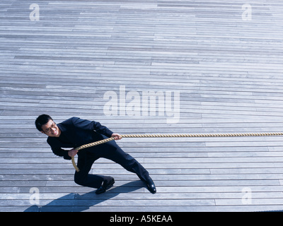 Asian Man pulling at a rope Stock Photo