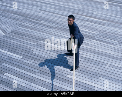 Asian Man pulling at a rope Stock Photo