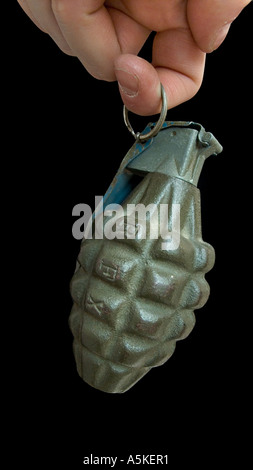 Hand grasping a hand grenade Familiar pineapple form M21 grenade USA Finger through the pin Black background Stock Photo