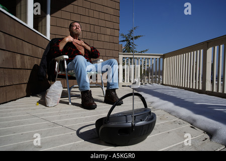 A man suntans in the dead of winter on an unusually warm day in Connecticut Stock Photo