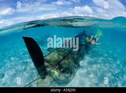 Under over photo of Japanese Zero fighter and snorkeler in shallow water Palau Micronesia Stock Photo