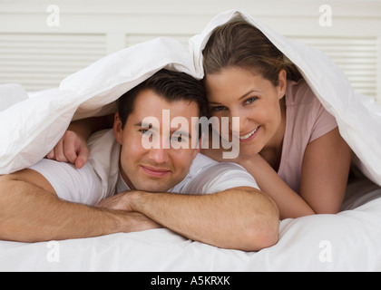 Portrait of couple under bed covers Stock Photo