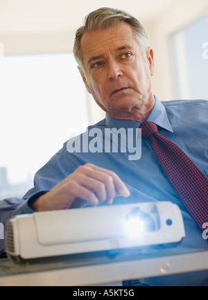 Senior businessman using projector in conference room Stock Photo