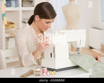 Woman using sewing machine Stock Photo