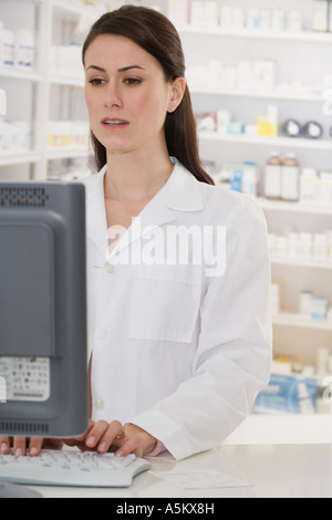 Female pharmacist typing on computer Stock Photo