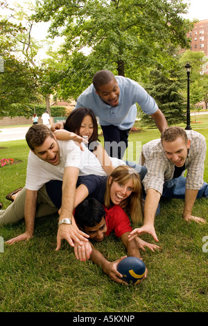 College students piling on in fun football game Stock Photo