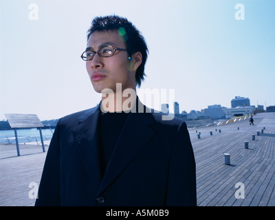 Asian man standing on a walkway Stock Photo
