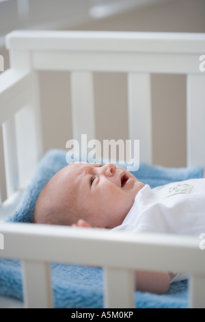 Baby crying in crib Stock Photo