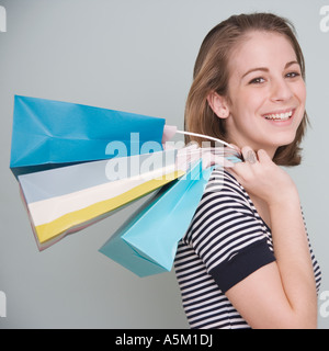 Teenage girl holding shopping bags over shoulder Stock Photo
