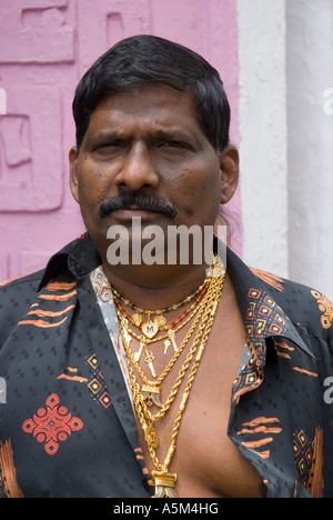 An Indian Malaysian making an ostentatious display of his wealth by wearing many gold chains Stock Photo