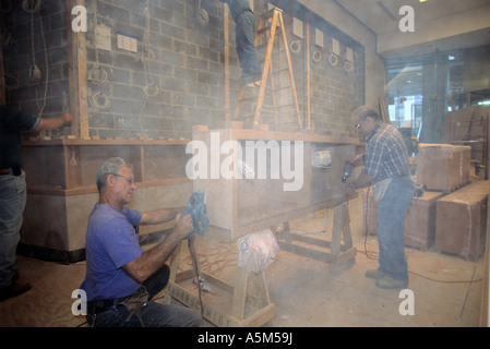 Master carpenters work on custom shelves for lobby in Random House building in New York City. Stock Photo