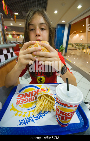 Teenage boy eating a Burger King hamburger Stock Photo