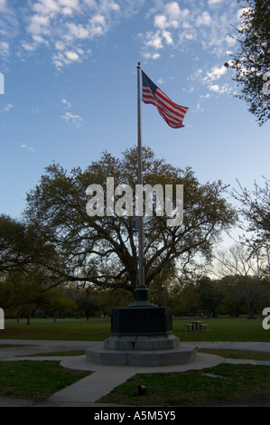 An American flag waves in the wind against a blue sky dotted with white clouds at dusk in Audubon Park in New Orleans LA before the devastating hurricane Katrina hit Stock Photo