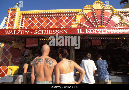young couple standing in front of a shooting booth on the Oktoberfest 2003 Munich Bavaria Germany  Stock Photo