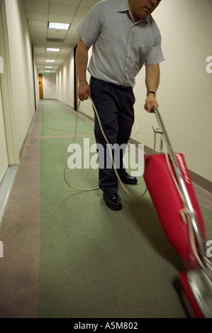 Janitor cleans hallway floor of hi rise office building Stock Photo
