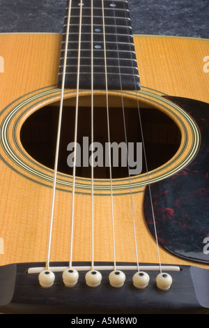 Close up of a Martin D 28 acoustic guitar showing the bridge strings sound hole pick guard and neck Stock Photo