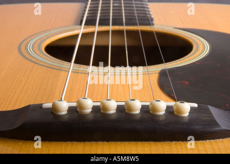 Close up of a Martin D 28 acoustic guitar showing the bridge strings sound hole pick guard and neck Stock Photo