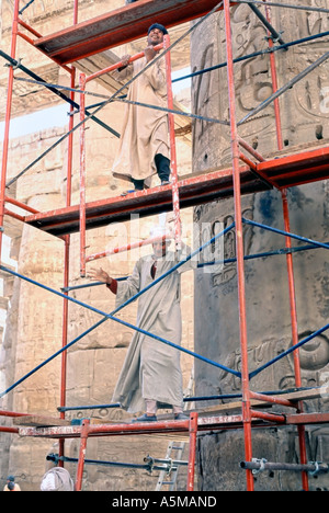 Karnak Egypt ,Egyptian Arab Construction  In 'Traditional Dress' Setting Up Scaffolding for Renovating Temple Stock Photo