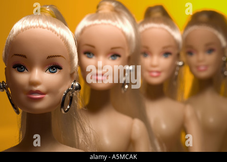 four dolls head and shoulders orange to yellow grad  background focus on middle point Stock Photo
