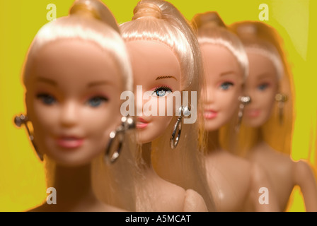 four dolls head and shoulders yellow grad background focus on front Stock Photo