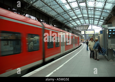 RAJ98758 Modern fast moving train transport red color at platform of Cologne Central Railway Station Germany Europe Stock Photo