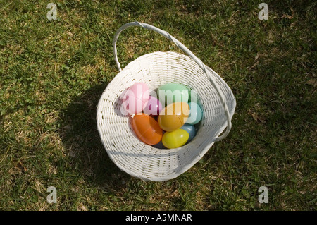 a white easter basket filled with plastic easter eggs on the lawn Stock Photo