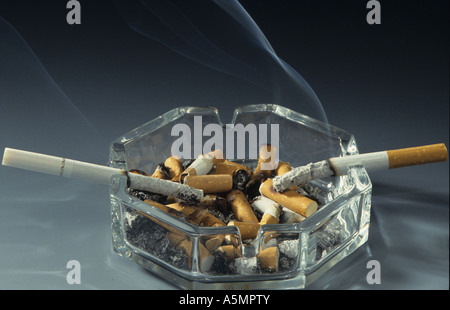 Voller Aschenbecher viele Zigarettenkippen angezündete Zigarette cigarette ends ashtray zwei angezündete Zigaretten Tabakkonsum Stock Photo