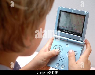 Junge spielt am Gameboy boy playing with Gameboy Kind Menschen Mensch Personen Leute people jung kindlich Kinder Kindheit child Stock Photo