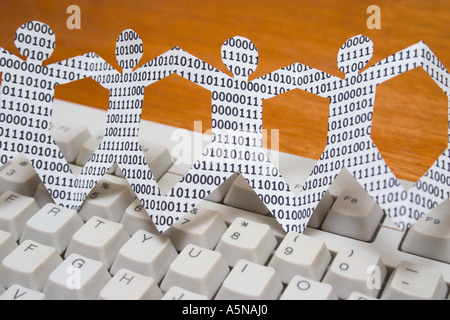 paper dolls with binary numbers on keyboard. symbolic of knowledge workers in the information technology industry Stock Photo