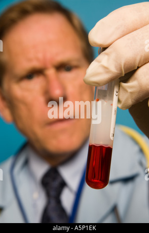 Physician inspects a blood sample in a test tube vial. Stock Photo