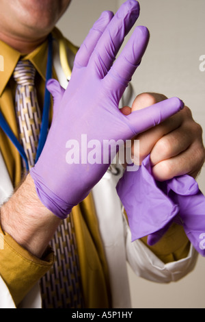 Doctor places latex glove on. Stock Photo