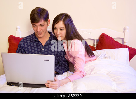 Using a laptop while still in bed. Stock Photo