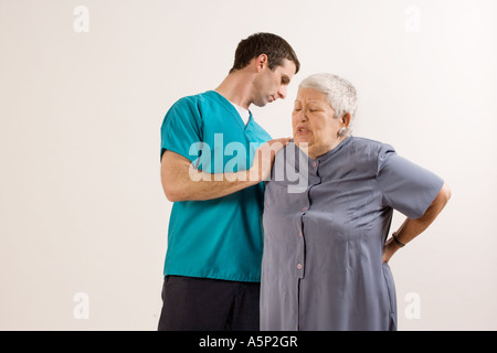 Woman explains were in hurts. I have lower back pain doctor. Please help me. Stock Photo