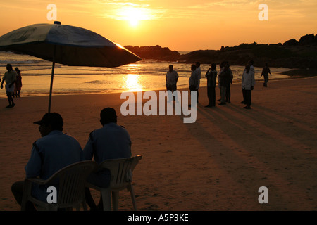 Men on the beach at sunset, Kovalam, southern india. Stock Photo